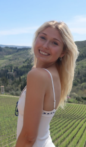 A woman in a white dress smiling. 